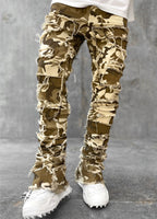 Men's tight-fit camo jeans with distressed fringe detailing, patchwork panels, and a stacked hem design.