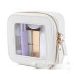 Small white square PU leather cosmetic bag with a transparent window, gold zipper, and visible beauty products inside.
