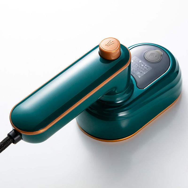 A dark green and gold portable travel iron with a spray button on the handle and a sleek, compact design.