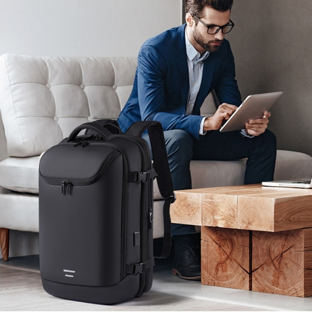 Black multifunctional vacuum compression backpack with sleek zippers, side buckles, and durable water-resistant material.