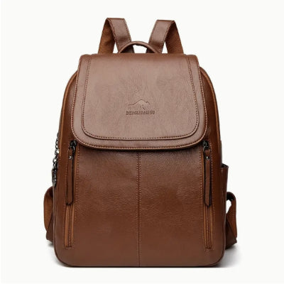 Brown soft leather backpack with flap top, vertical front zipper pockets, and kangaroo logo detail against white.