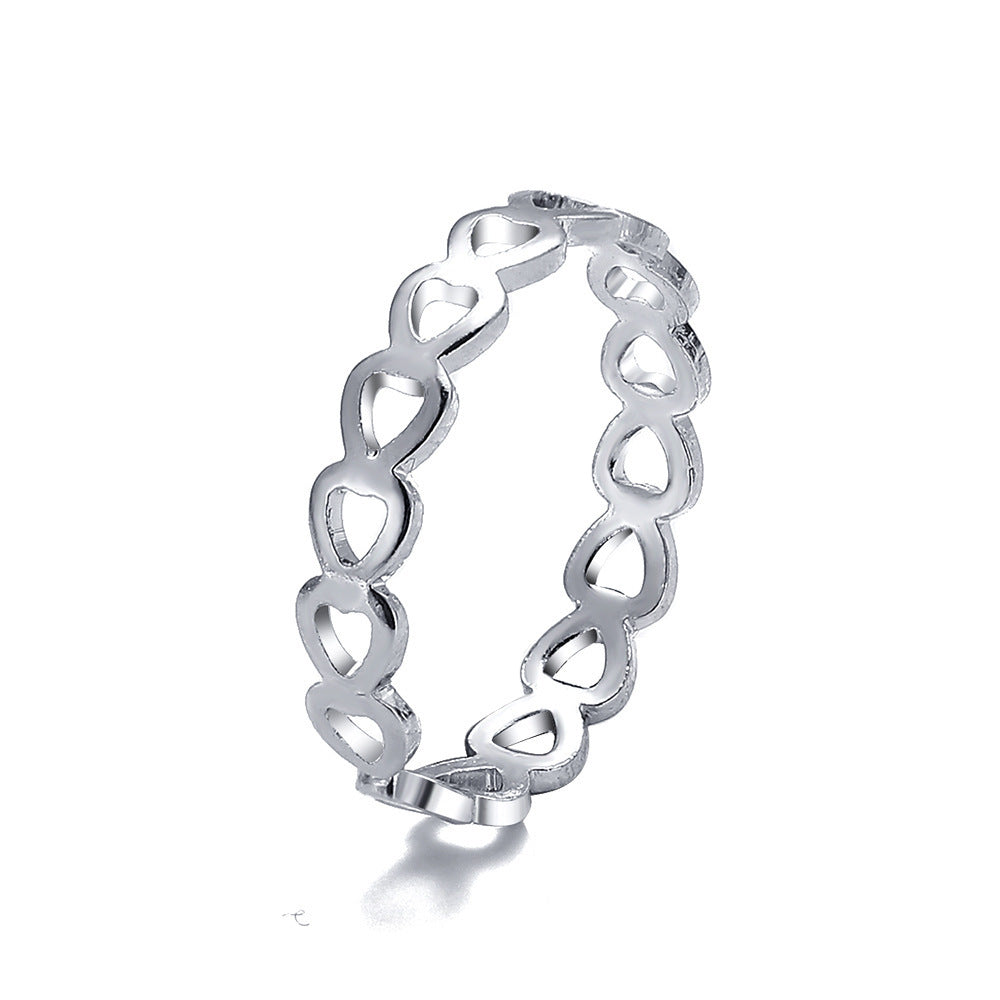 Silver-tone metal ring featuring a continuous band of connected, open-work heart shapes on a white background.