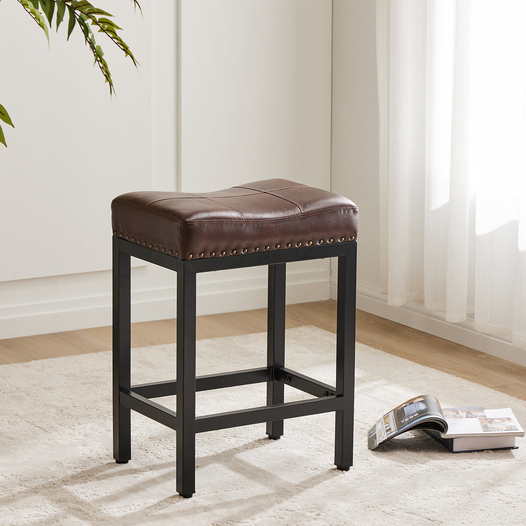 Brown saddle-seat stool with nailhead trim and a black steel frame, set in a bright room on a white rug.