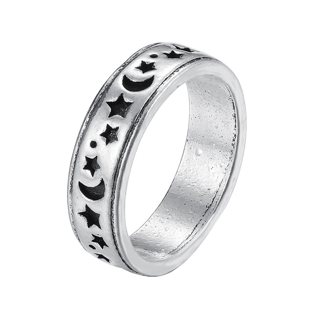 Silver-tone ring with a blackened engraved pattern of stars, crescents, and dots in a street-style design.