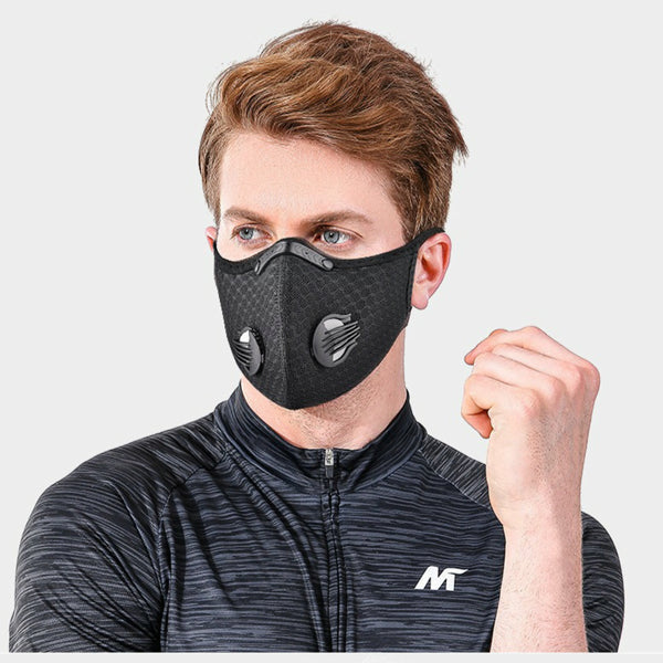 A man wearing a black, reusable, textured half-face mask featuring two side air valves for cycling or sports.