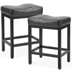 Two black saddle bar stools with black steel frames, cushioned leather-look seats, and antique nailhead trim.
