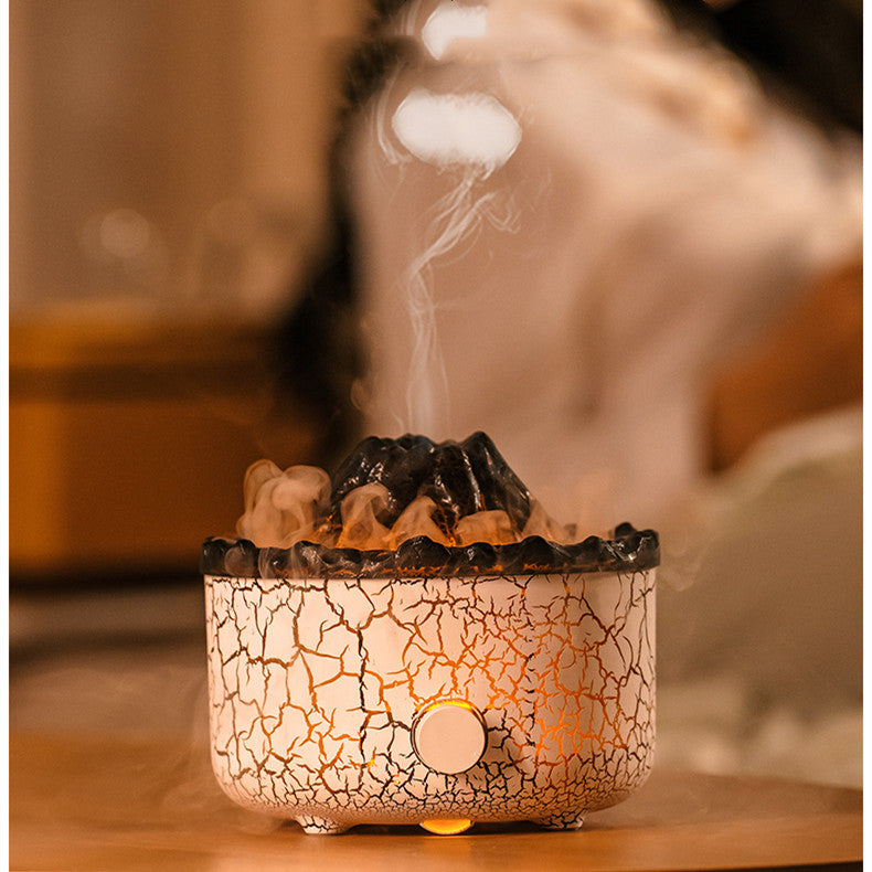 Volcano humidifier with a white crackle texture, glowing amber light, and emitting jellyfish-shaped mist rings.