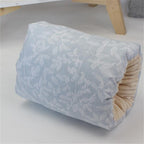 Blue nursing arm pillow with white leaf pattern and soft beige ribbed interior for baby feeding support.