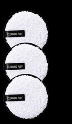 Three round, white, fuzzy microfiber cleansing makeup remover pads with black labels reading "CLEANING PUFF."