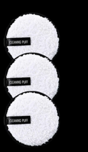 Three round, white, fuzzy microfiber cleansing makeup remover pads with black labels reading "CLEANING PUFF."