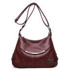 Burgundy soft leather shoulder bag with an adjustable strap, silver hardware accent, and kangaroo logo emblem.