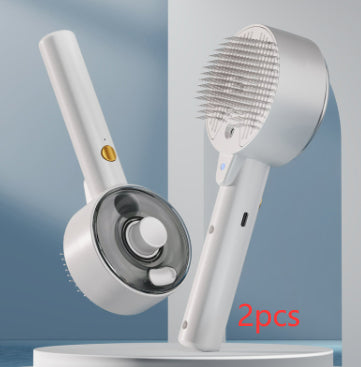 Two white, plastic self-cleaning steam brushes for pets with fine metal bristles and gold power buttons.