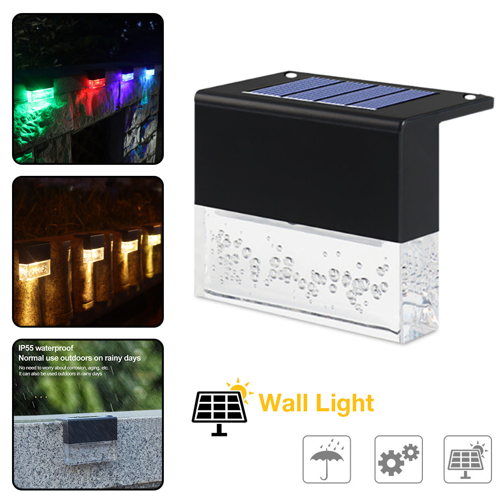 Black solar step light with bubble-textured glass, RGB LED glow, and waterproof design for fences and walls.