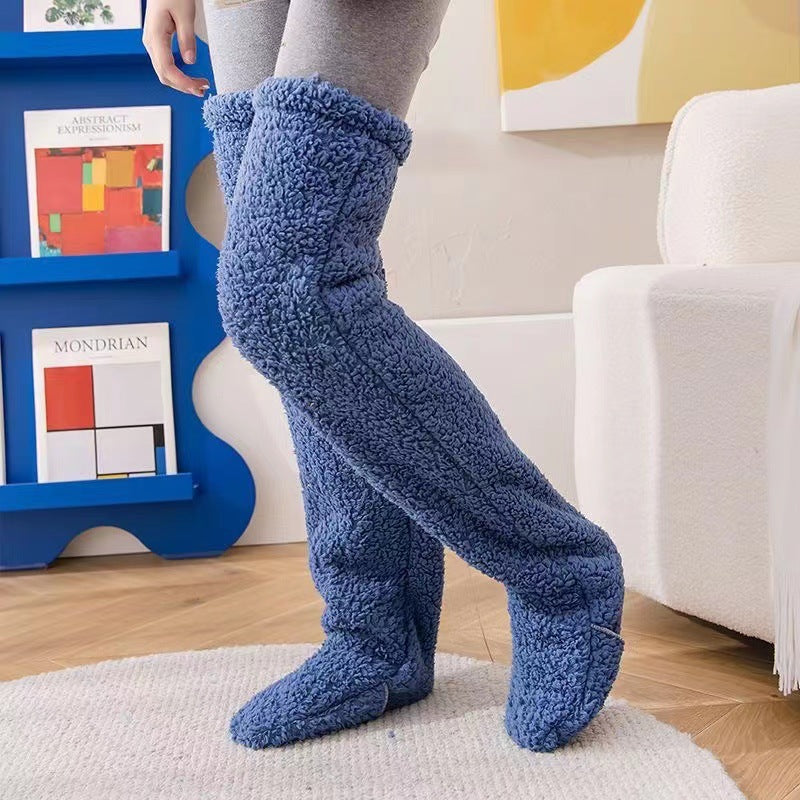 Plush blue fleece over-the-knee leg warmers covering gray leggings, providing cozy indoor warmth.
