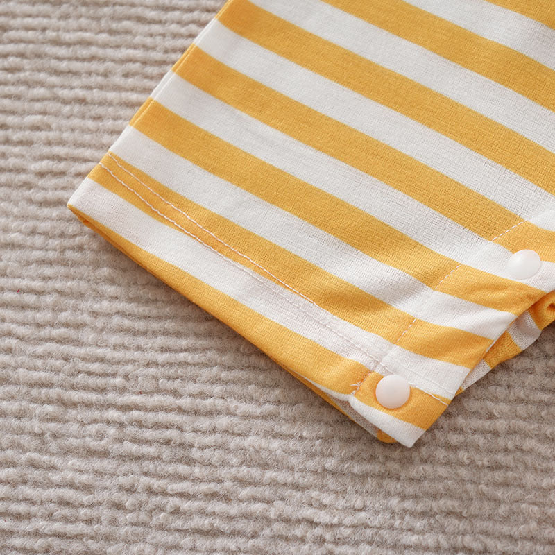 Close-up of a soft yellow and white striped baby cotton jumpsuit sleeve with white snap buttons.