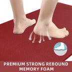 Bare feet on a textured, red waterproof memory foam kitchen mat showing pressure rebound, white background.