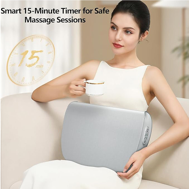 Woman in white sitting on a couch, holding a light gray, fabric-covered rectangular back massager with side controls.