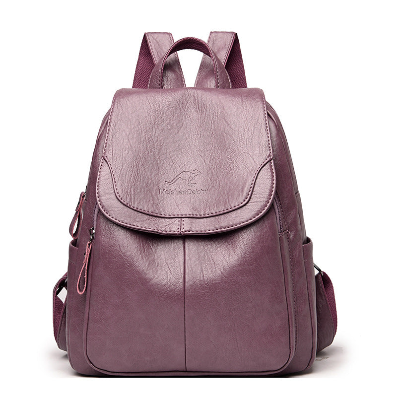A purple soft leather casual backpack with a flap top, kangaroo logo, and matching fabric shoulder straps.