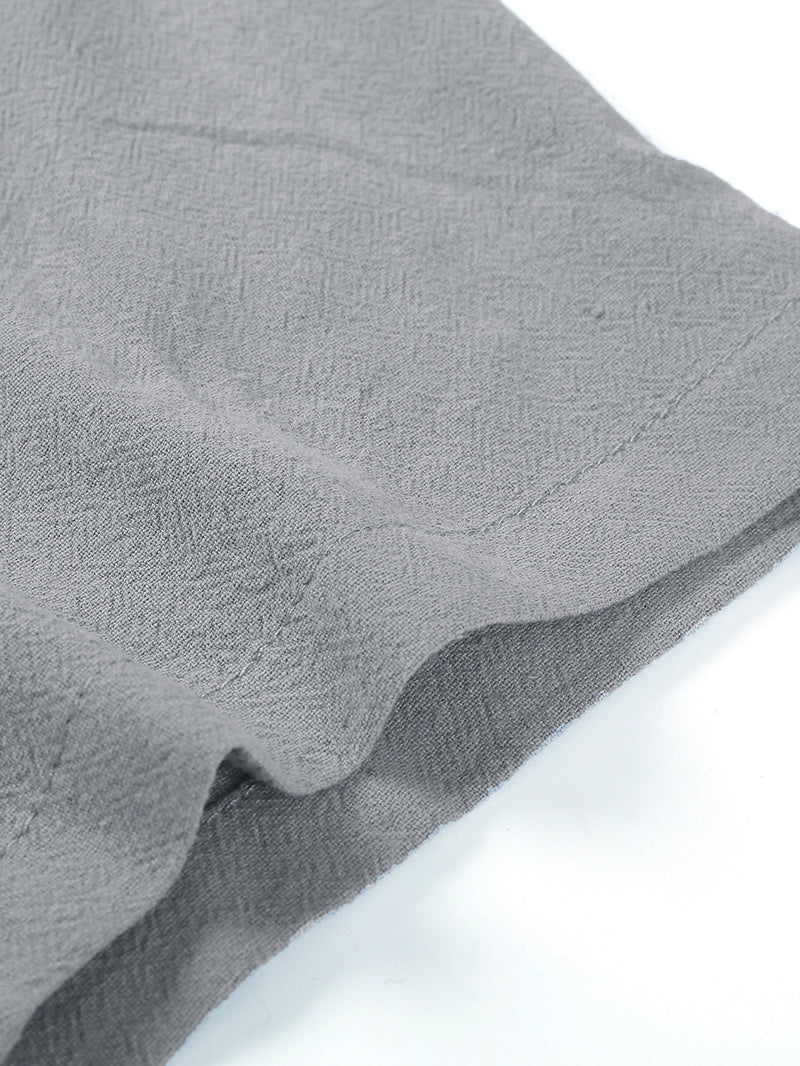 Close-up of a grey, textured short-sleeve shirt sleeve featuring visible stitching and a lightweight, casual fabric.
