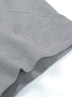 Close-up of a grey, textured short-sleeve shirt sleeve featuring visible stitching and a lightweight, casual fabric.