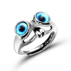 Silver frog-shaped hip hop ring featuring two prominent, vibrant blue glass eyes, isolated on a white background.