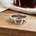 Silver ring featuring etched butterfly motifs on the outer band and the engraved phrase "Your Soul Shine" inside.