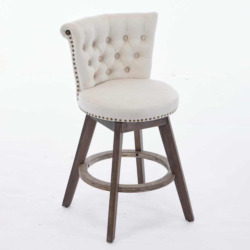 Beige tufted velvet swivel bar stool with nailhead trim and brown wooden legs on a white background.