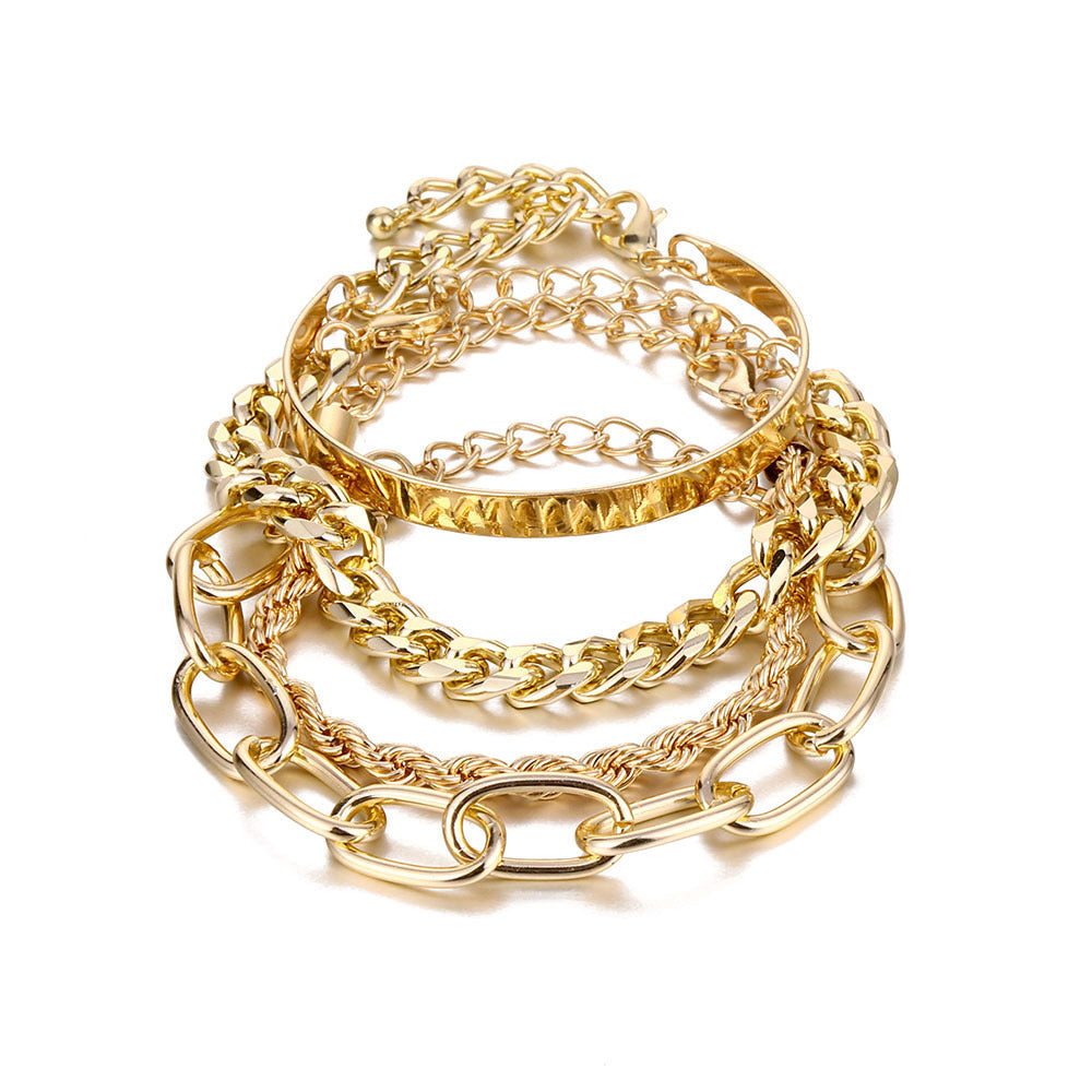 A stacked set of gold-tone hip hop bracelets, featuring Cuban links, twisted ropes, and a sleek metal bangle.