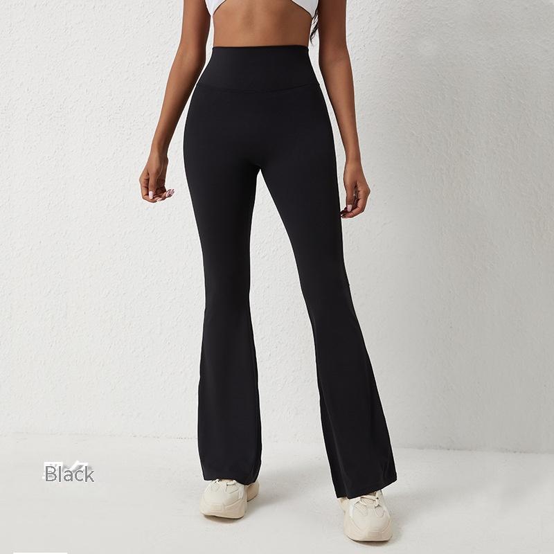Model wearing black, high-waisted, flared yoga pants with a smooth, stretchy fabric finish against a white background.