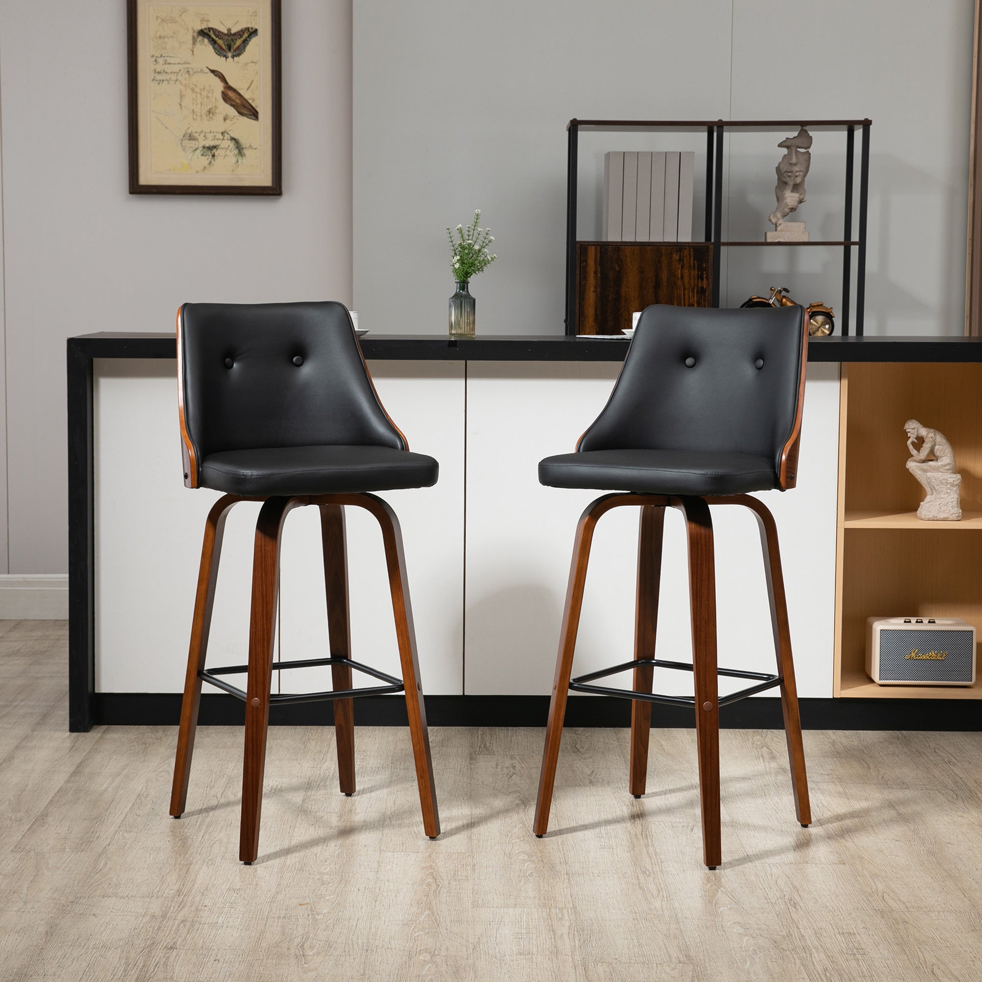 Two bar-height swivel stools with black tufted faux leather seats and walnut-finished wood frames in a modern kitchen.