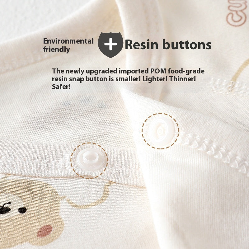 Close-up of cream-colored organic cotton baby romper featuring safe, food-grade resin snap buttons and cute print.