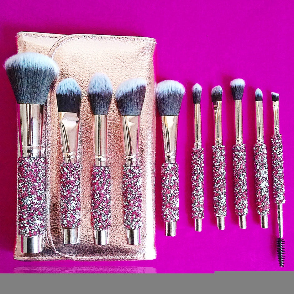 10-piece makeup brush set with pink diamond-inlaid handles, soft bristles, and a metallic rose-gold storage pouch.