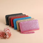 Six glittery, zip-around multi-functional women's clutches in various colors, each featuring a convenient wrist strap.
