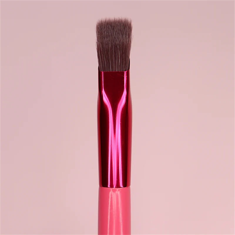 Squared-off eyebrow makeup brush with brown synthetic bristles, a shiny magenta metal ferrule, and a pink handle.