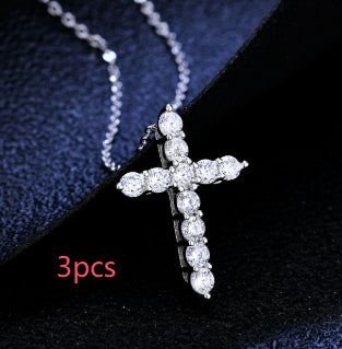 A silver-toned chain necklace featuring a cross pendant encrusted with sparkling clear round-cut faux diamonds.
