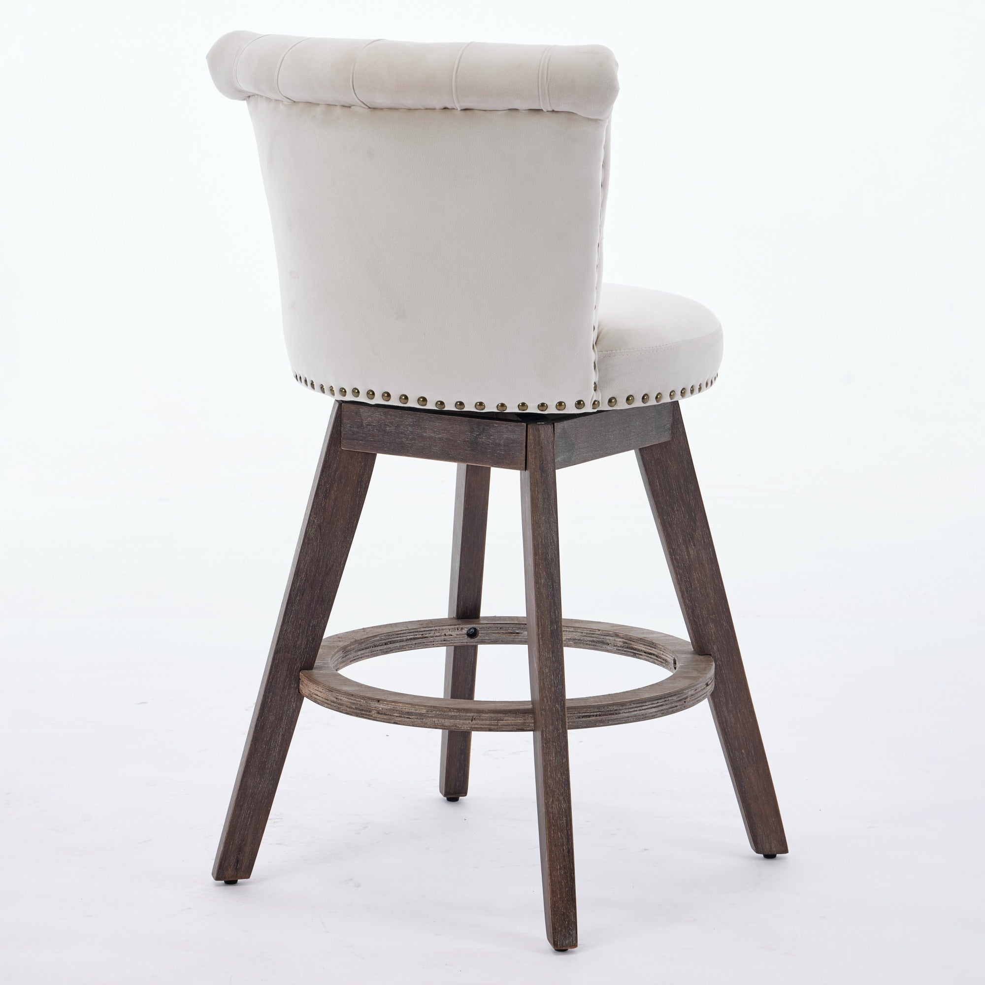 Beige tufted velvet swivel bar stool with nailhead trim and brown wooden legs on a white background.