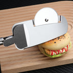 Stainless steel 3-in-1 pizza cutter with circular blade and integrated spatula, resting on a wooden cutting board.