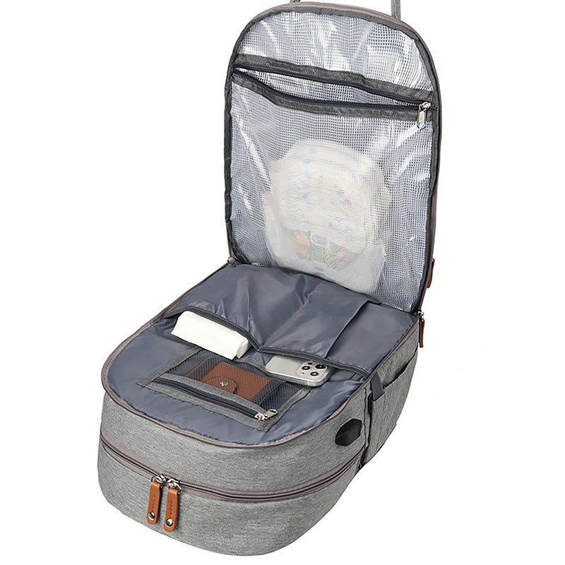 Open grey fabric stroller diaper bag with mesh lid, internal storage pockets, and external USB charging port.