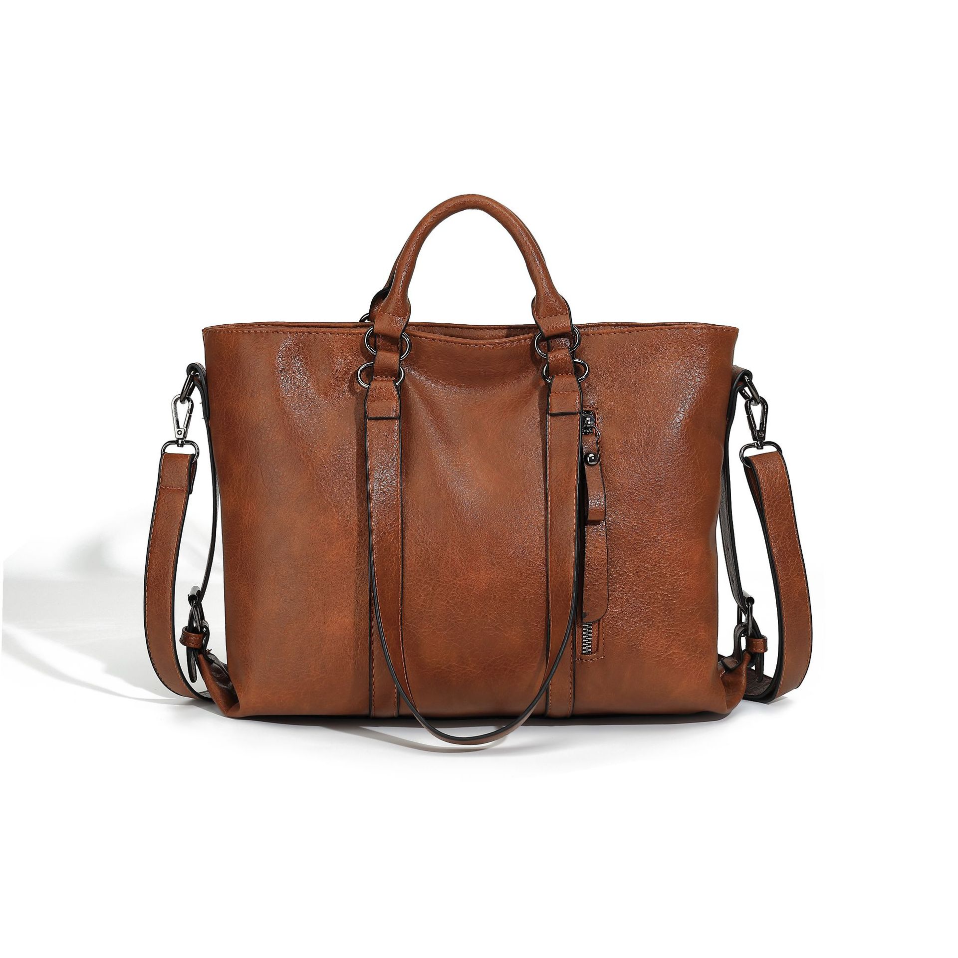 Brown soft leather tote bag with dual handles, side zipper detail, and an adjustable, detachable shoulder strap.