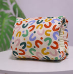 Washable cotton baby nursing arm pillow featuring a colorful, patterned U-shaped print on a cream background.