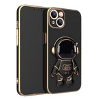 Black phone case with gold electroplated trim and a 3D astronaut figure that serves as a stand.