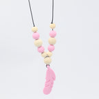 Baby teether necklace with pink silicone feather pendant and alternating natural wood and pink silicone beads.