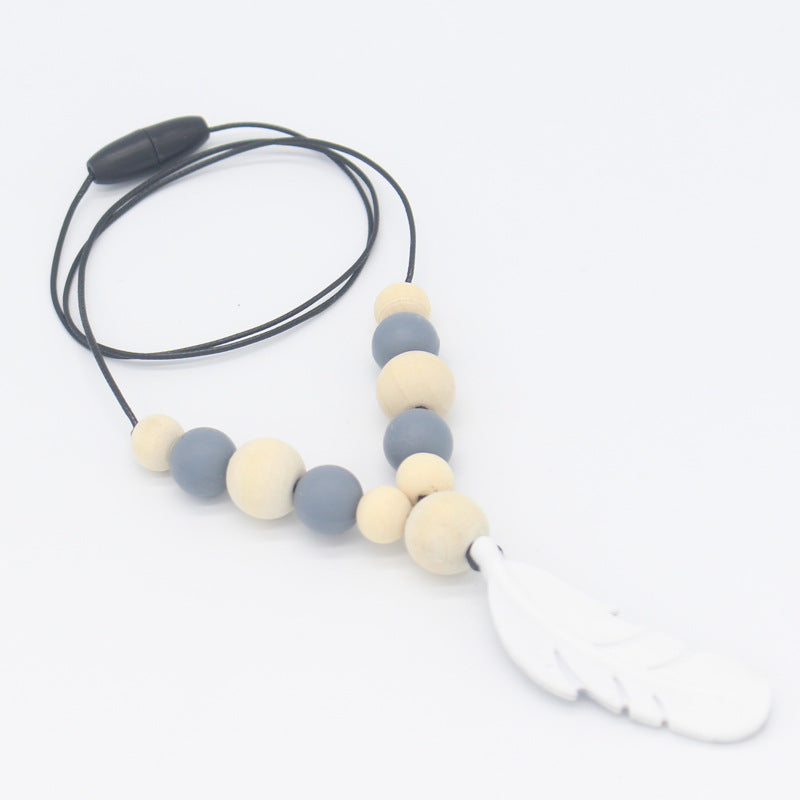 Teether necklace with grey silicone and natural wood beads, finished with a white silicone feather pendant on a cord.