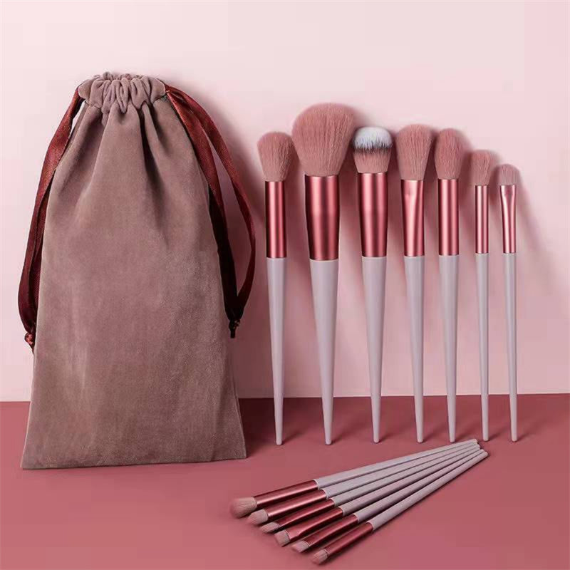 13-piece rose gold and light pink makeup brush set with soft bristles and a matching drawstring storage pouch.