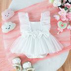 White baby tutu jumpsuit with ruffled sleeves, double bows, and tulle skirt on a soft pink background with accessories.