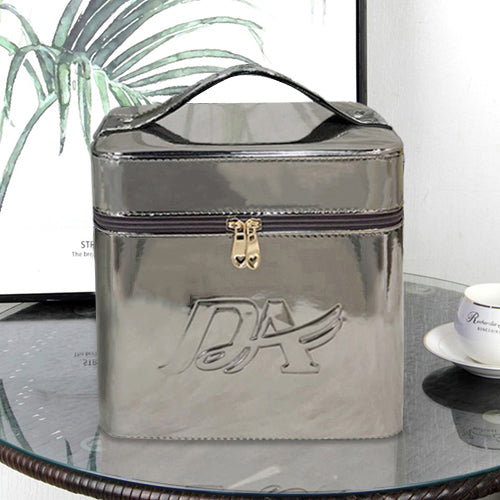 Metallic silver square portable makeup bag with top handle, zipper closure, and embossed logo on the front.