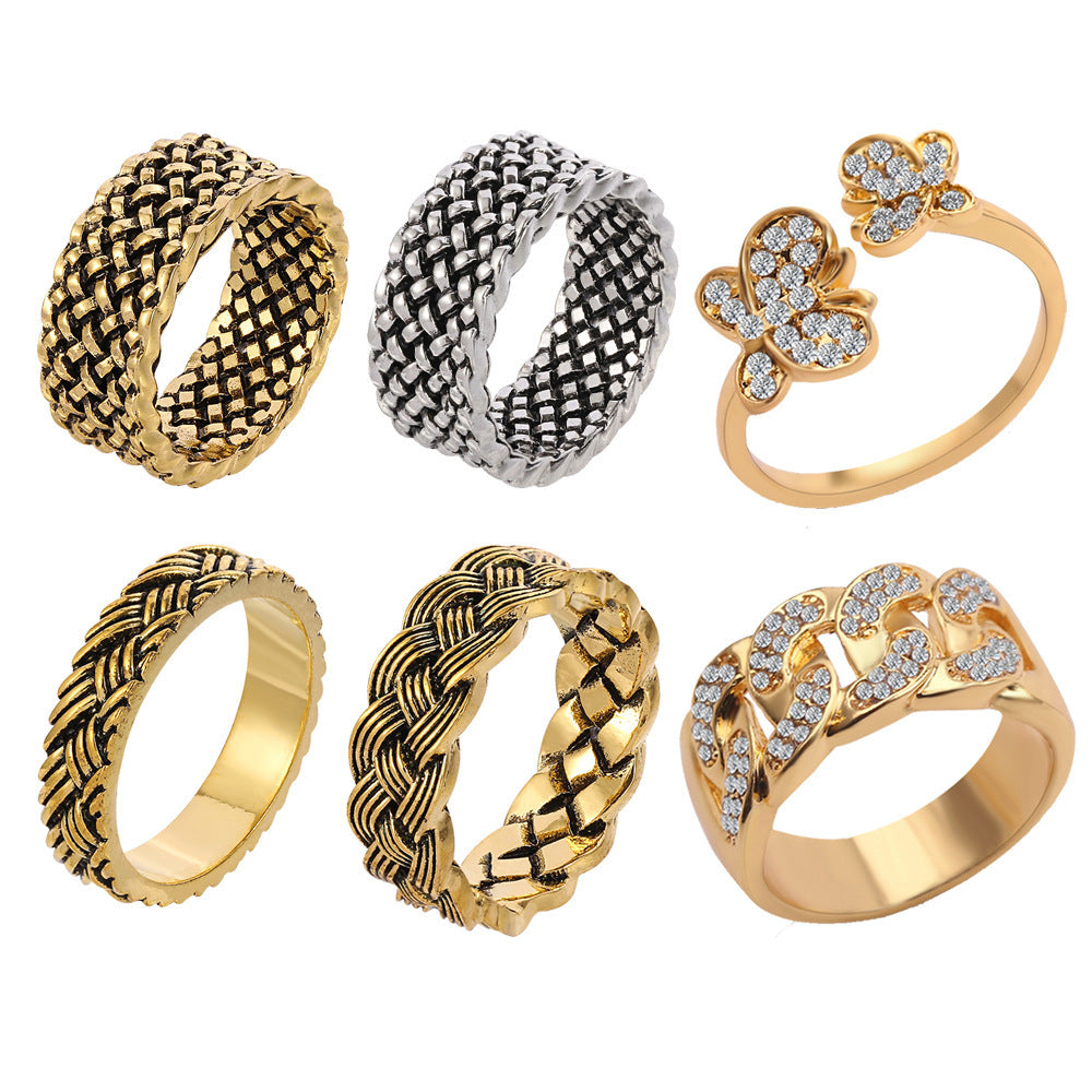 A set of six rings featuring gold and silver braided, woven, and diamond-studded butterfly and Cuban link designs.