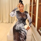 Woman wearing a long-sleeve, black and white abstract print mesh midi dress with a sleek, body-conscious silhouette.