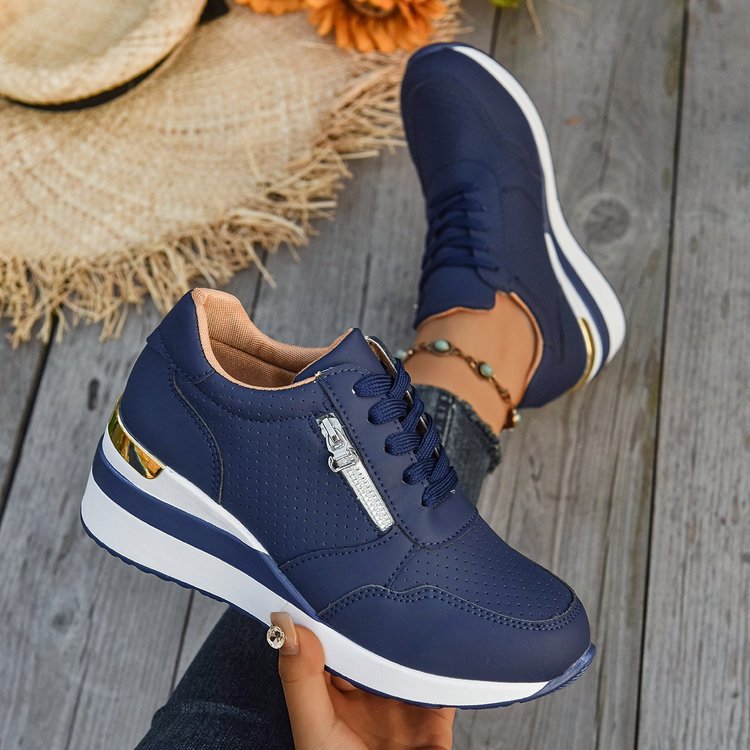 Navy blue perforated sneakers with side zippers, lace-up fronts, white platform soles, and metallic gold heel accents.