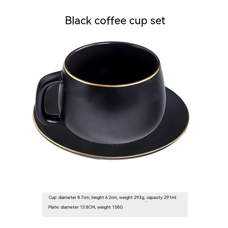 A matte black ceramic coffee cup and matching saucer with elegant gold-rimmed edges against a plain white background.